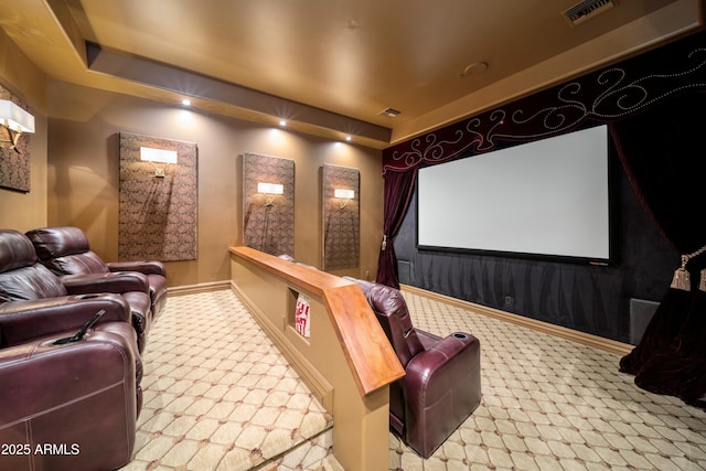 carpeted cinema room with a raised ceiling