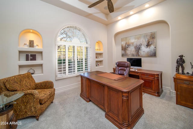 carpeted office with built in features and ceiling fan