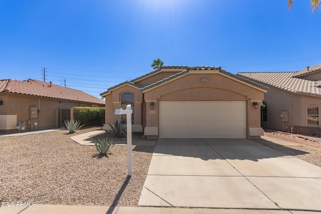 mediterranean / spanish-style home featuring a tile roof, stucco siding, an attached garage, and concrete driveway