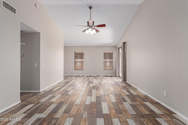 spare room with visible vents, baseboards, vaulted ceiling, wood finished floors, and a ceiling fan