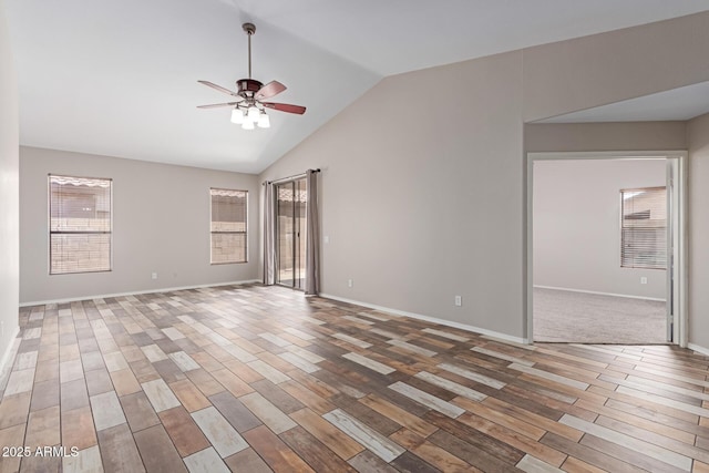 unfurnished room with baseboards, lofted ceiling, wood finished floors, and a ceiling fan