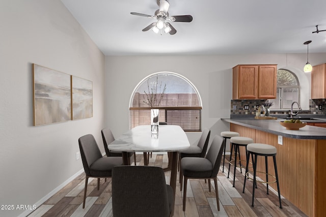 dining area featuring baseboards, wood finished floors, and a ceiling fan