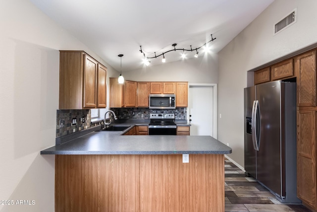 kitchen with visible vents, lofted ceiling, appliances with stainless steel finishes, a peninsula, and a sink