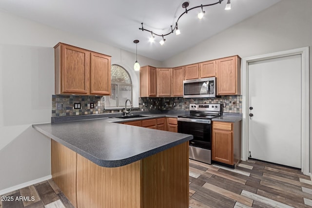 kitchen featuring dark countertops, appliances with stainless steel finishes, tasteful backsplash, and vaulted ceiling