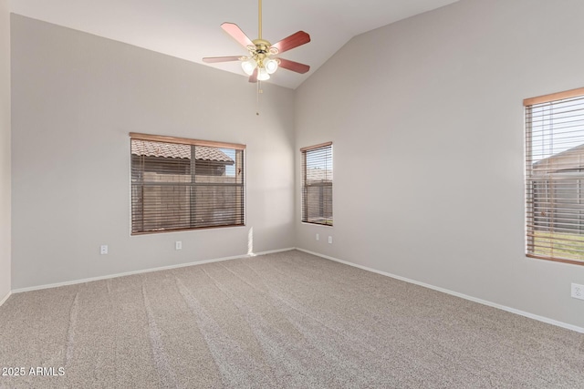 empty room with vaulted ceiling, carpet flooring, a ceiling fan, and baseboards