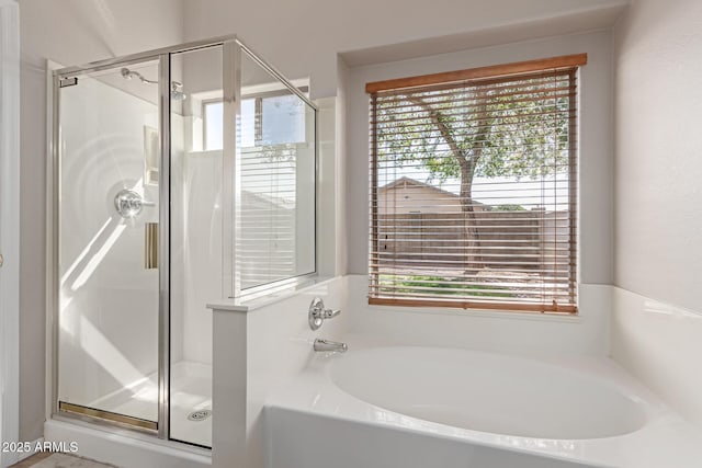 bathroom featuring a garden tub and a shower stall