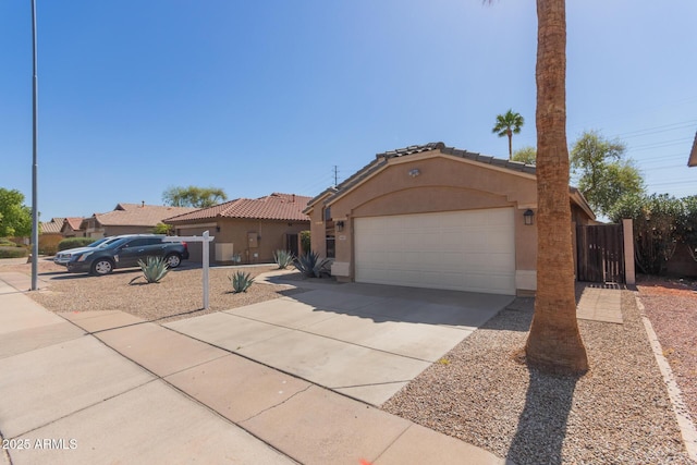 mediterranean / spanish house featuring stucco siding, fence, concrete driveway, a garage, and a tiled roof