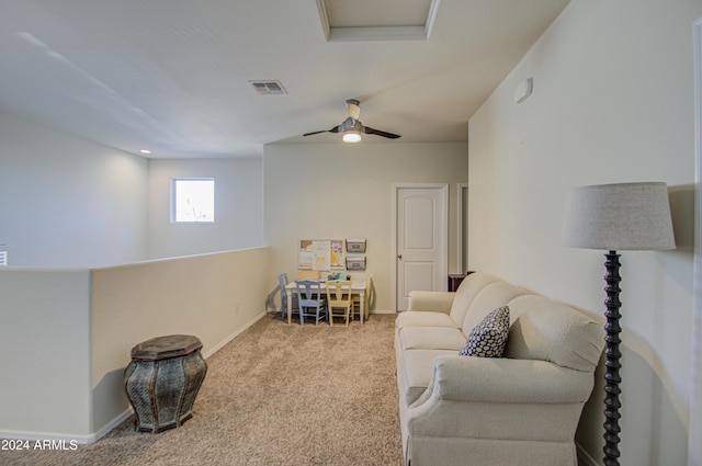 living area featuring light colored carpet and ceiling fan