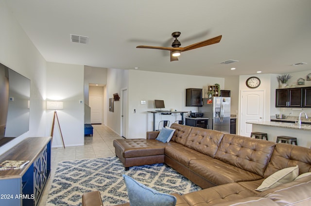 living room featuring ceiling fan, sink, and light tile patterned floors