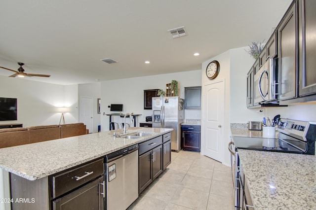 kitchen with sink, ceiling fan, light tile patterned floors, an island with sink, and appliances with stainless steel finishes