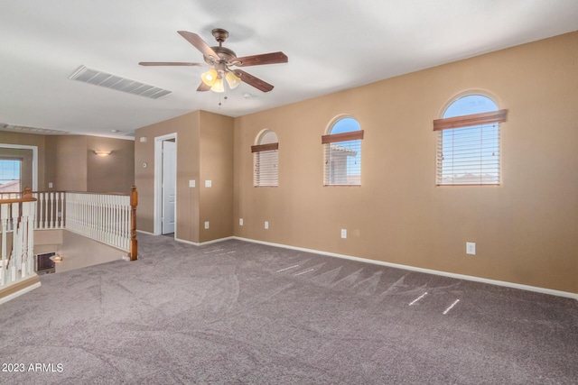 unfurnished room with visible vents, baseboards, carpet, and a ceiling fan