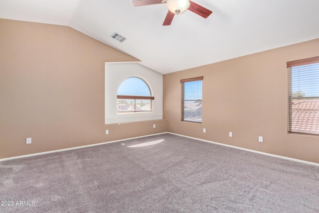 carpeted empty room featuring baseboards, visible vents, lofted ceiling, and a healthy amount of sunlight