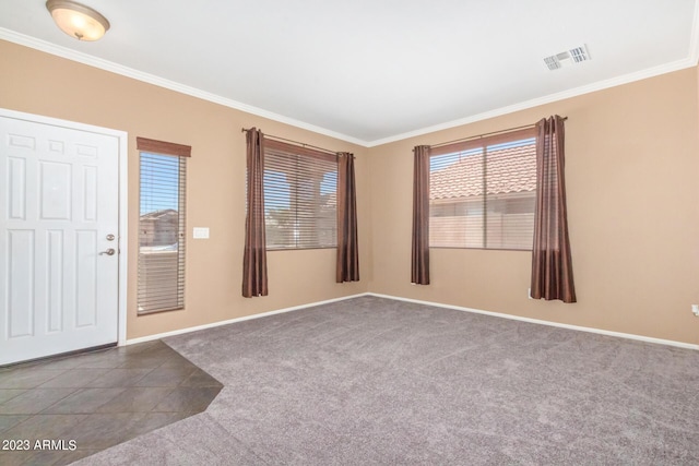 carpeted empty room with tile patterned flooring, baseboards, visible vents, and ornamental molding