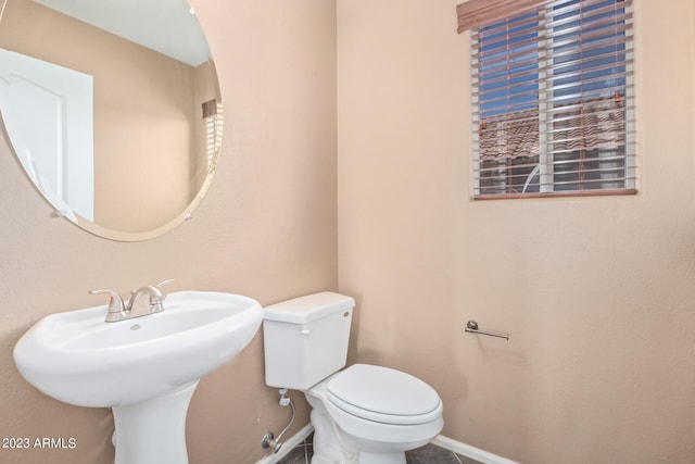 bathroom featuring a sink, baseboards, and toilet