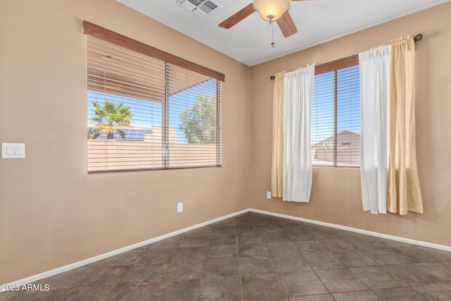 empty room with visible vents, baseboards, and ceiling fan