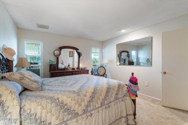 bedroom with light colored carpet and a textured ceiling