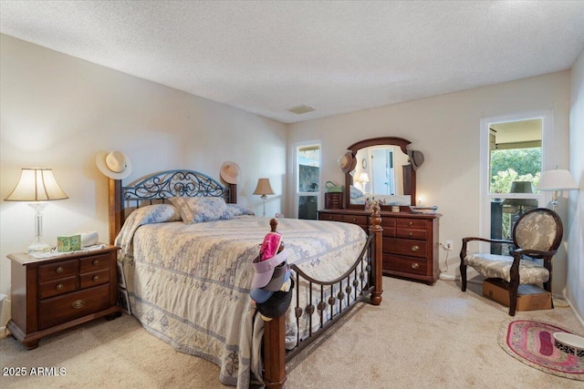 bedroom featuring light carpet and a textured ceiling