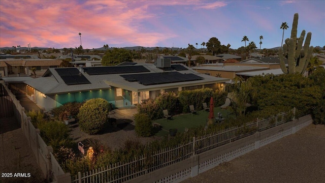 back house at dusk featuring solar panels