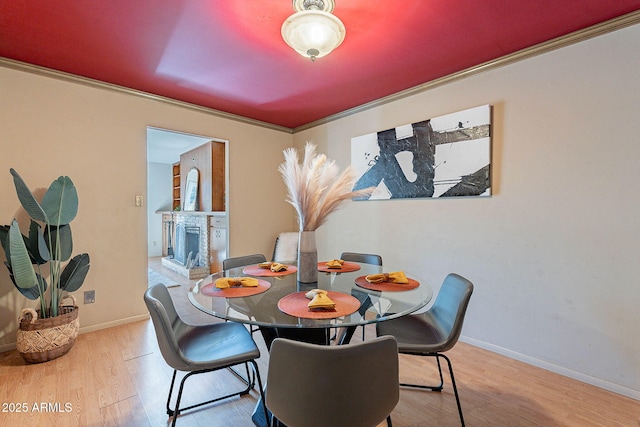 dining area with crown molding and light hardwood / wood-style flooring