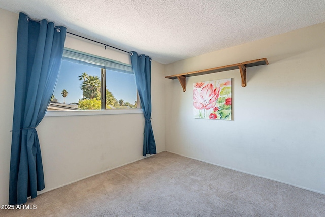 carpeted spare room featuring a textured ceiling