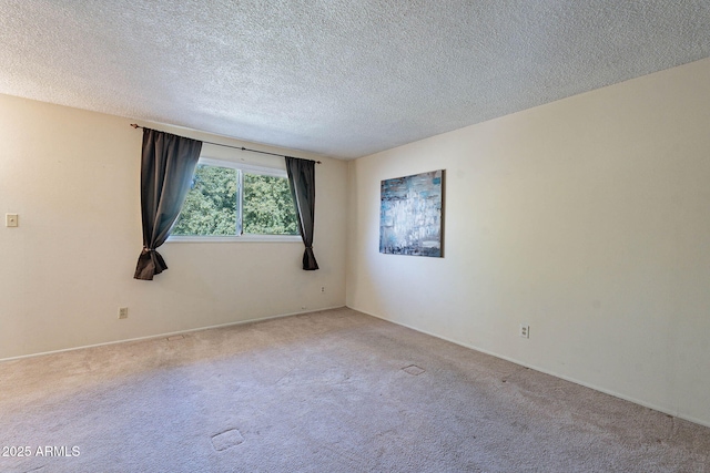 unfurnished room featuring light carpet and a textured ceiling