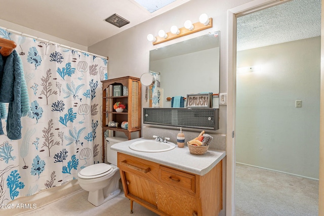 bathroom featuring vanity, toilet, a textured ceiling, and a skylight