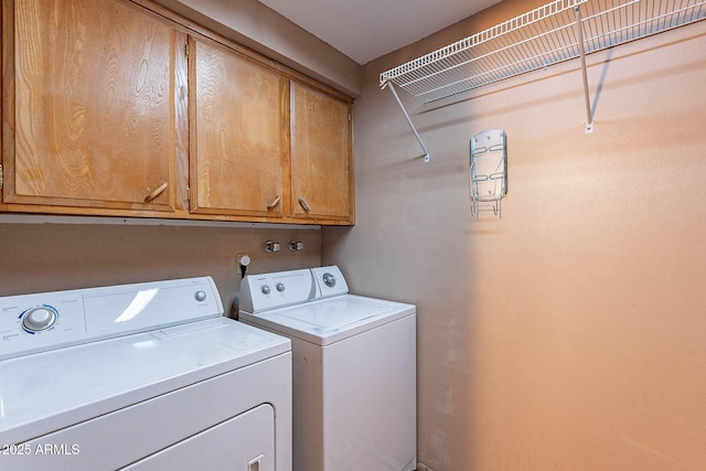 laundry room with cabinets and washer and clothes dryer