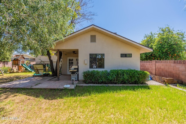 rear view of property featuring a patio area, a playground, and a lawn