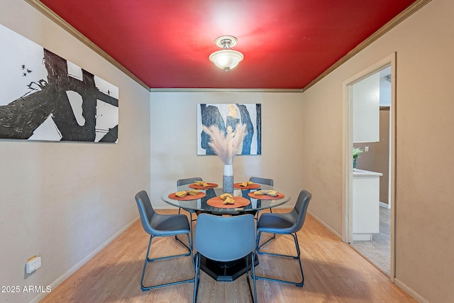 dining area with ornamental molding and light wood-type flooring