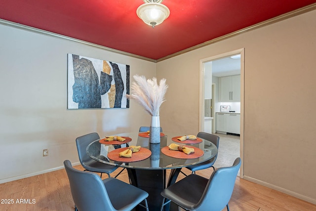 dining room featuring ornamental molding and light hardwood / wood-style floors