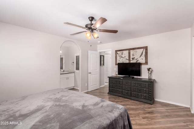 20750 E Chase Ct, Florence, AZ 85132 - bedroom with wood finished floors, arched walkways, ensuite bathroom, and ceiling fan