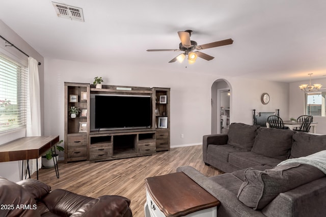 20750 E Chase Ct, Florence, AZ 85132 - living room featuring arched walkways, a ceiling fan, wood finished floors, and a chandelier