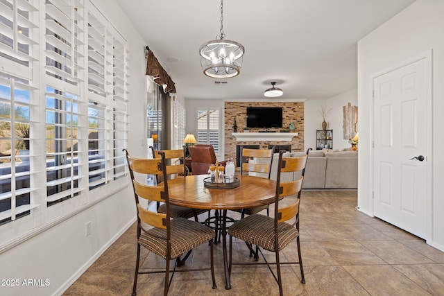 dining room featuring a fireplace and a chandelier