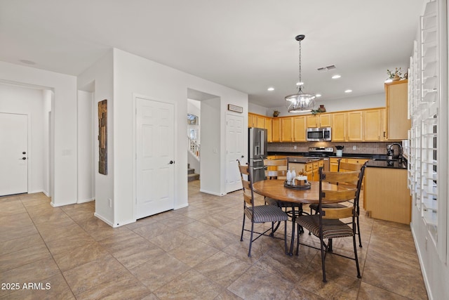 dining space with sink and an inviting chandelier