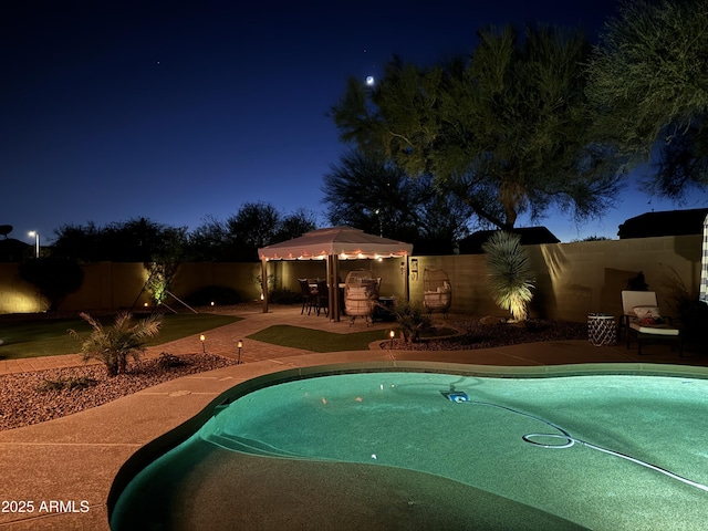 pool at night with a patio area