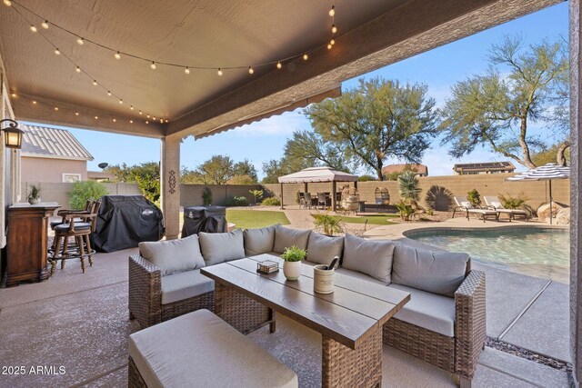 view of patio / terrace featuring a fenced in pool, a grill, a bar, and an outdoor hangout area