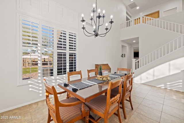 dining room featuring a towering ceiling, a notable chandelier, and light tile patterned flooring