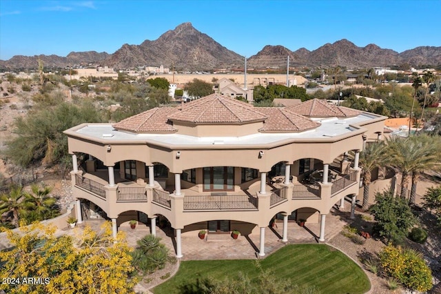 back of house featuring a mountain view and a balcony