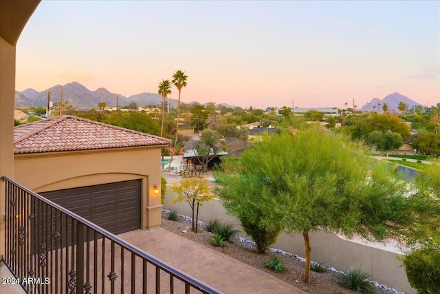 balcony at dusk featuring a mountain view