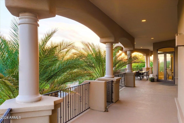 patio terrace at dusk featuring a balcony