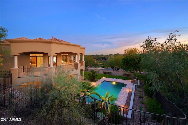 pool at dusk with a patio