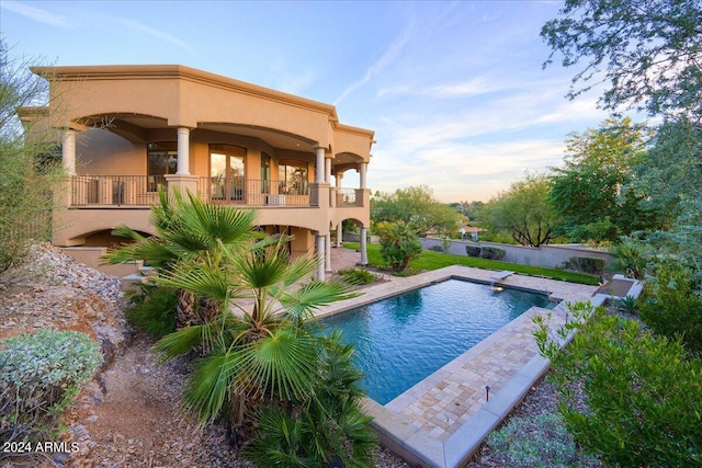 rear view of property featuring a balcony and a patio area