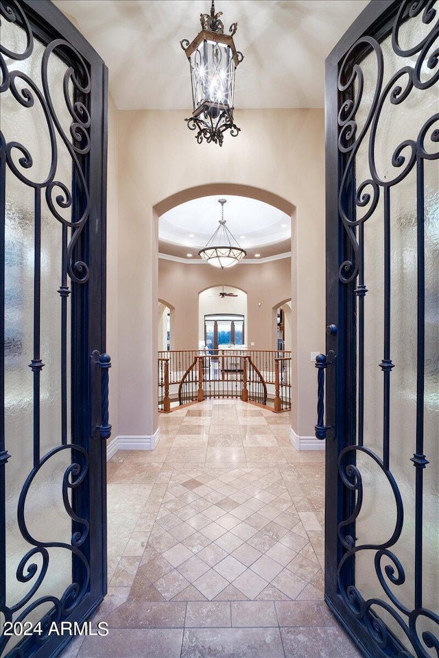 foyer featuring an inviting chandelier and crown molding