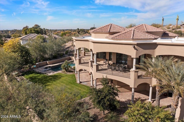 back of property with a lawn and a patio area