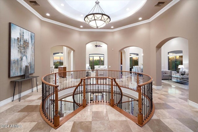 hallway with crown molding and a towering ceiling