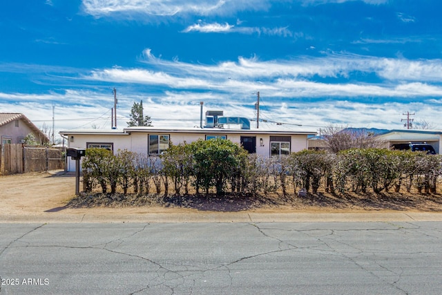 ranch-style home with driveway, a garage, and fence