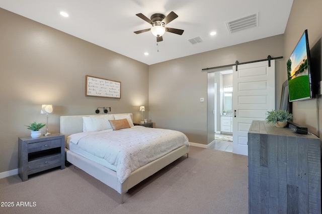 carpeted bedroom featuring a barn door and ceiling fan