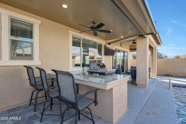 view of patio / terrace featuring a bar, area for grilling, and ceiling fan