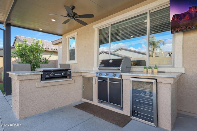 view of patio featuring exterior kitchen, grilling area, beverage cooler, and ceiling fan