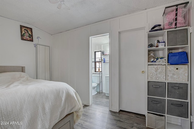 bedroom with dark hardwood / wood-style floors, a textured ceiling, and ensuite bathroom